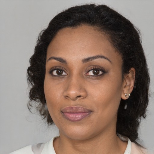 Joyful black young-adult female with medium  brown hair and brown eyes