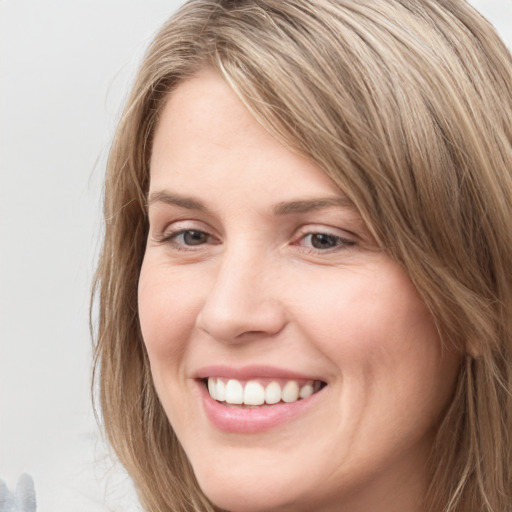 Joyful white young-adult female with long  brown hair and grey eyes