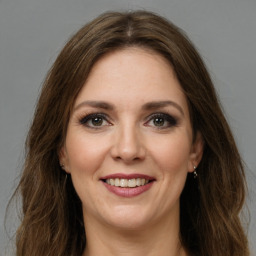 Joyful white young-adult female with long  brown hair and green eyes