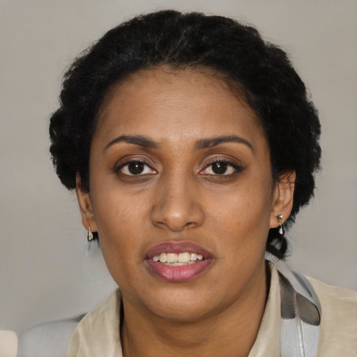 Joyful black adult female with short  black hair and brown eyes
