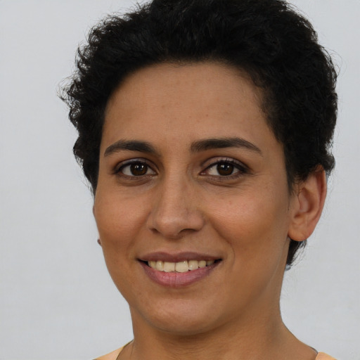 Joyful latino young-adult female with short  brown hair and brown eyes