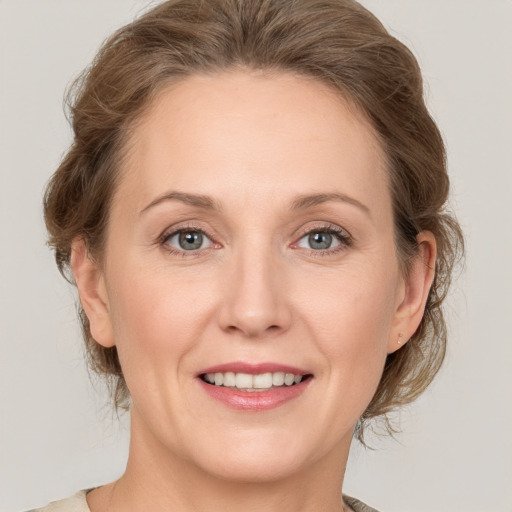 Joyful white adult female with medium  brown hair and grey eyes