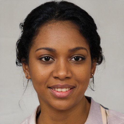 Joyful black young-adult female with medium  black hair and brown eyes