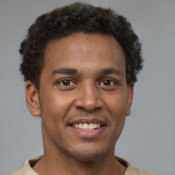 Joyful latino young-adult male with short  brown hair and brown eyes