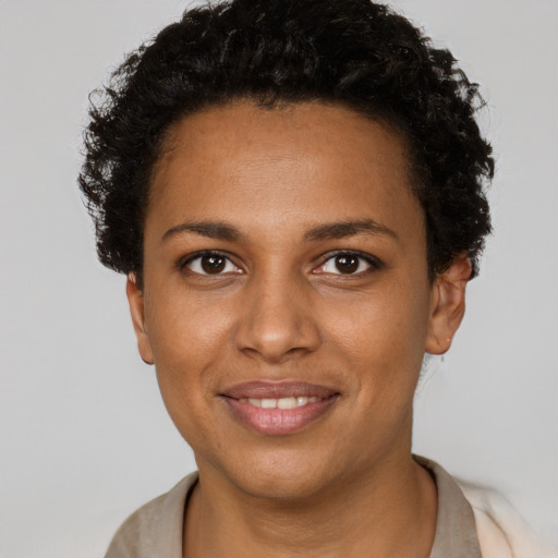 Joyful black young-adult female with short  brown hair and brown eyes