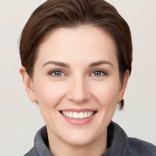 Joyful white young-adult female with short  brown hair and grey eyes