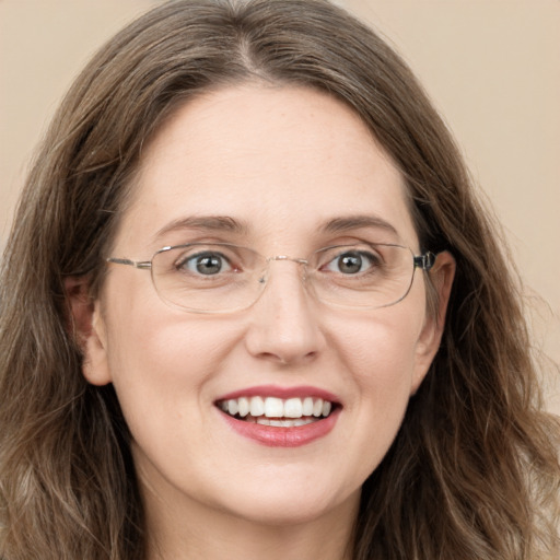 Joyful white adult female with long  brown hair and green eyes