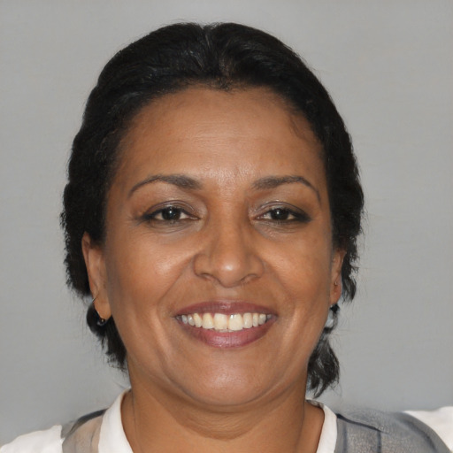 Joyful latino adult female with medium  brown hair and brown eyes