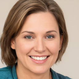 Joyful white young-adult female with medium  brown hair and grey eyes