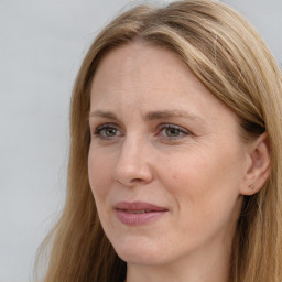 Joyful white adult female with long  brown hair and brown eyes