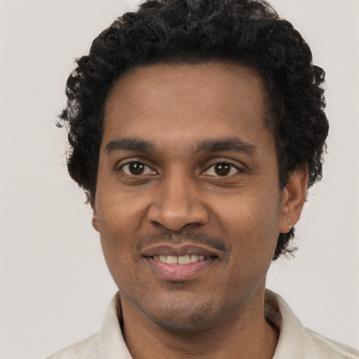 Joyful black adult male with short  black hair and brown eyes