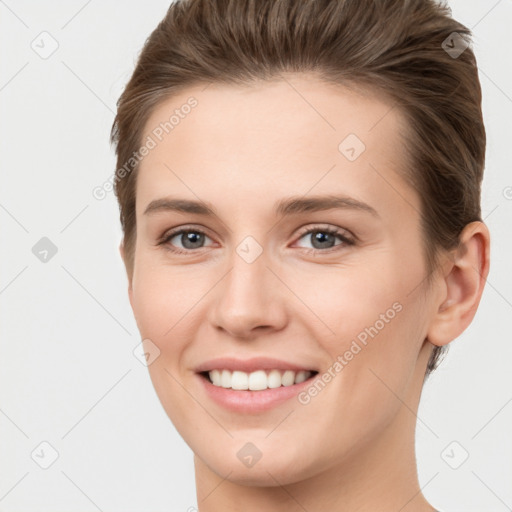 Joyful white young-adult female with short  brown hair and grey eyes