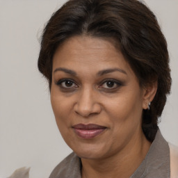 Joyful black adult female with medium  brown hair and brown eyes