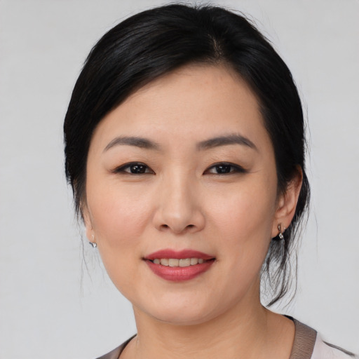 Joyful asian young-adult female with medium  black hair and brown eyes