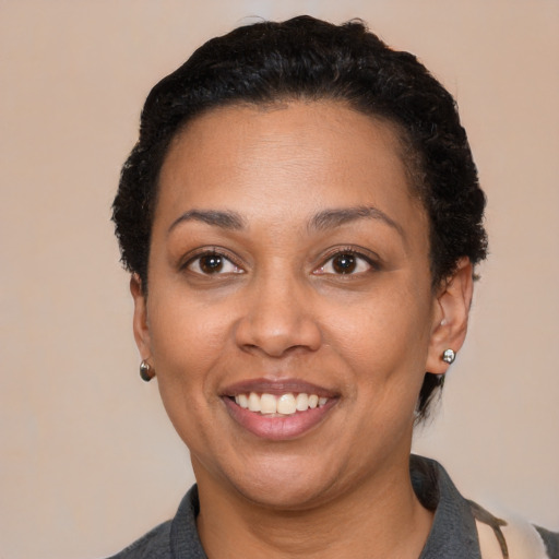 Joyful latino adult female with short  black hair and brown eyes