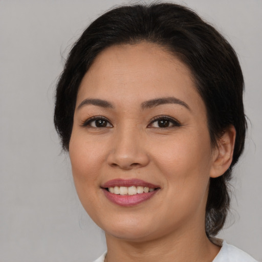 Joyful asian young-adult female with medium  brown hair and brown eyes