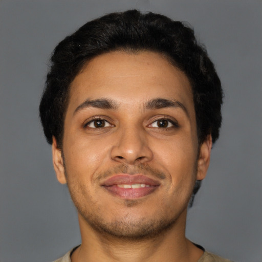 Joyful latino young-adult male with short  brown hair and brown eyes