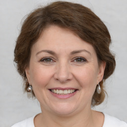 Joyful white adult female with medium  brown hair and grey eyes