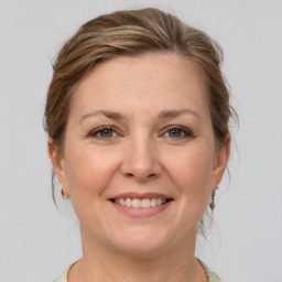 Joyful white adult female with medium  brown hair and grey eyes