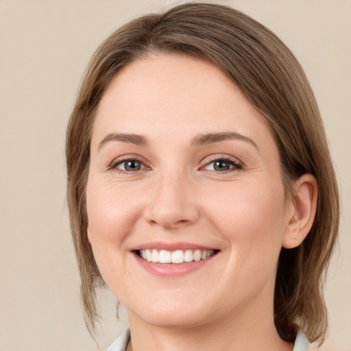 Joyful white young-adult female with medium  brown hair and green eyes