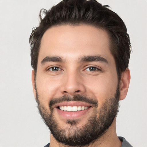 Joyful white young-adult male with short  black hair and brown eyes