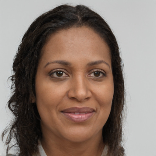 Joyful black young-adult female with long  brown hair and brown eyes