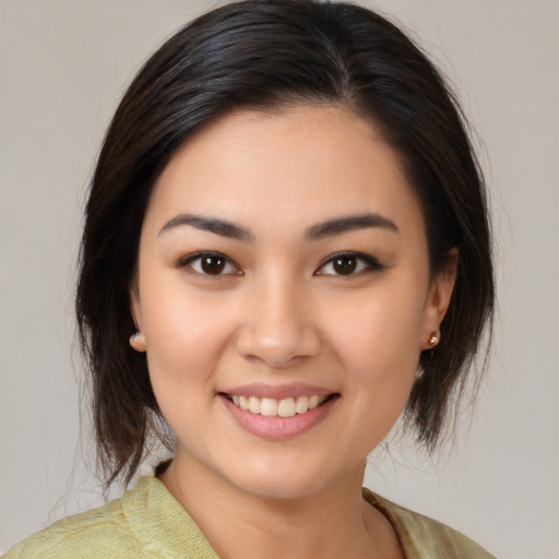 Joyful latino young-adult female with medium  brown hair and brown eyes