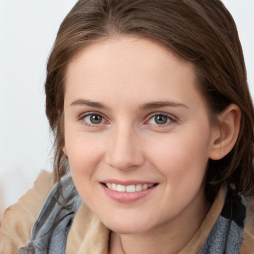 Joyful white young-adult female with medium  brown hair and grey eyes