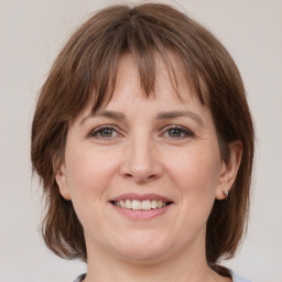 Joyful white adult female with medium  brown hair and grey eyes