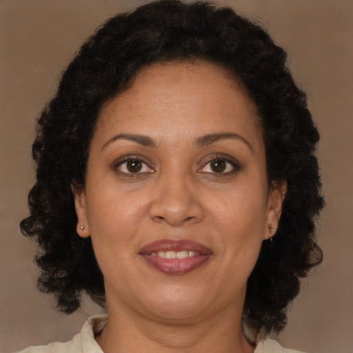 Joyful latino adult female with medium  brown hair and brown eyes