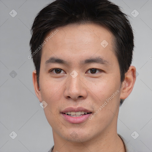 Joyful asian young-adult male with short  brown hair and brown eyes