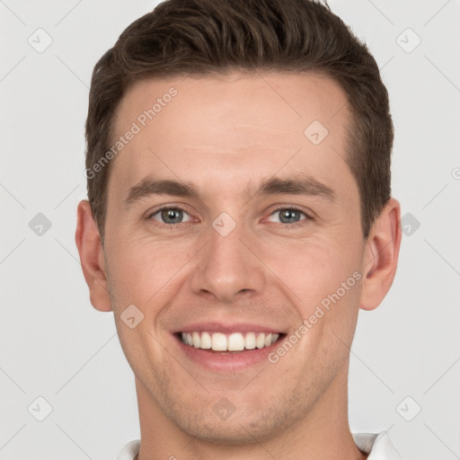 Joyful white young-adult male with short  brown hair and grey eyes