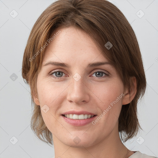 Joyful white young-adult female with medium  brown hair and grey eyes