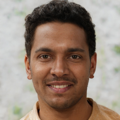Joyful black young-adult male with short  brown hair and brown eyes