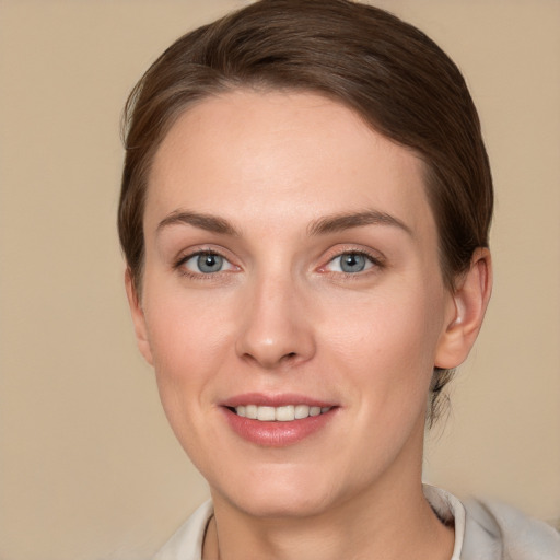 Joyful white young-adult female with medium  brown hair and grey eyes