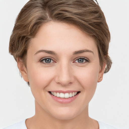 Joyful white young-adult female with short  brown hair and grey eyes