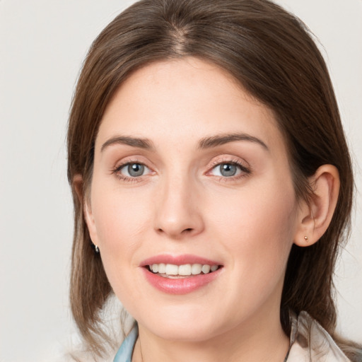 Joyful white young-adult female with medium  brown hair and grey eyes