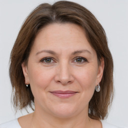 Joyful white adult female with medium  brown hair and grey eyes