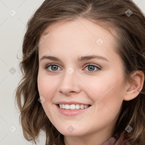 Joyful white young-adult female with long  brown hair and blue eyes