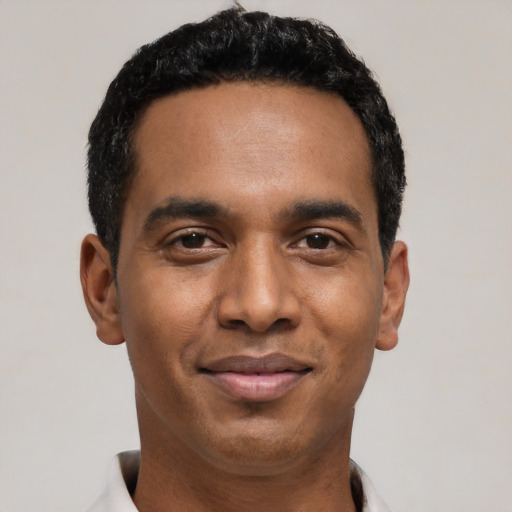 Joyful black young-adult male with short  black hair and brown eyes