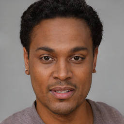 Joyful black young-adult male with short  black hair and brown eyes