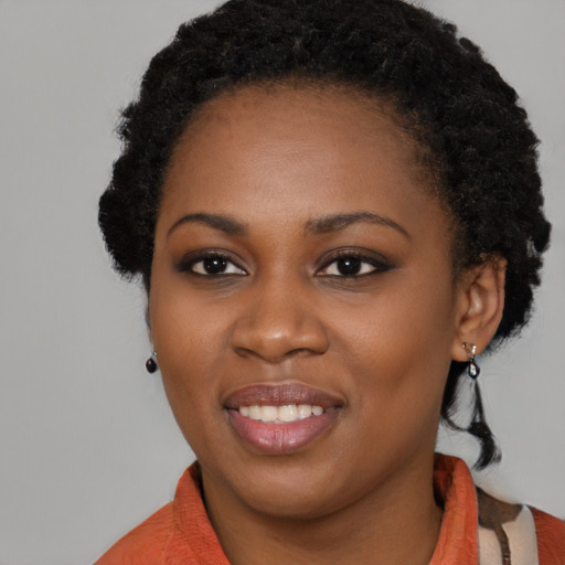 Joyful black young-adult female with medium  black hair and brown eyes