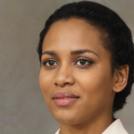 Joyful black young-adult female with short  black hair and brown eyes