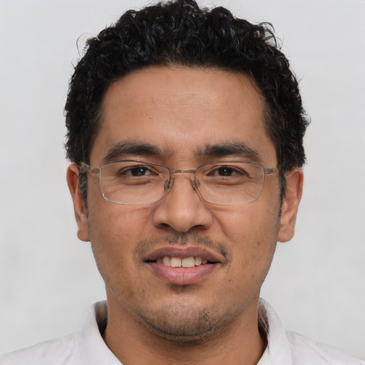 Joyful latino adult male with short  brown hair and brown eyes