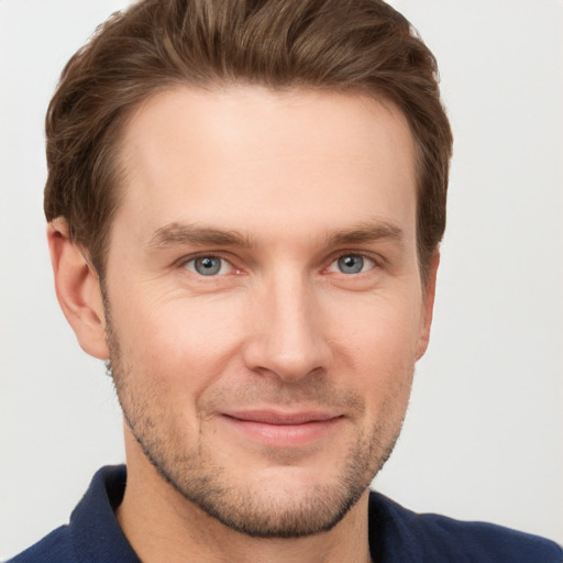 Joyful white young-adult male with short  brown hair and grey eyes