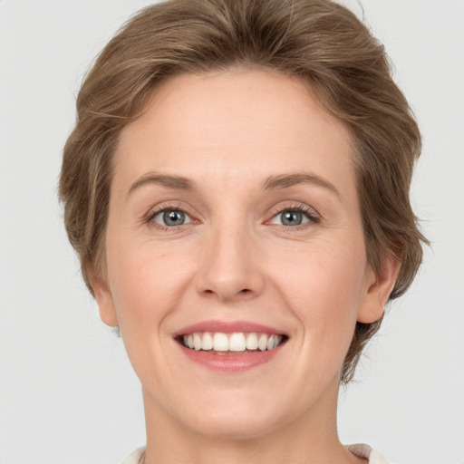 Joyful white adult female with medium  brown hair and blue eyes