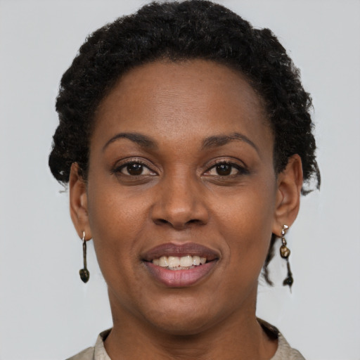 Joyful black young-adult female with short  brown hair and brown eyes