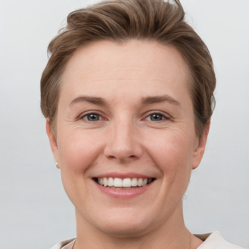 Joyful white young-adult female with short  brown hair and grey eyes