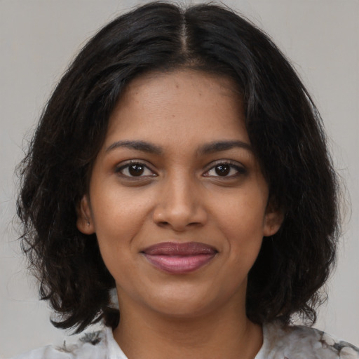 Joyful black young-adult female with medium  brown hair and brown eyes