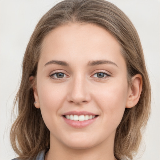 Joyful white young-adult female with medium  brown hair and grey eyes